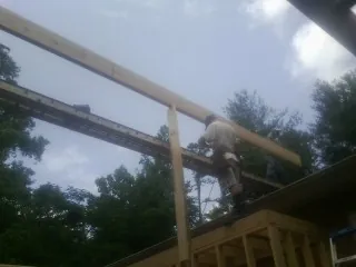 Carpenter setting a ridge beam over a new addition frame — Ice Dam Removal by Roofing Brothers in Ramey