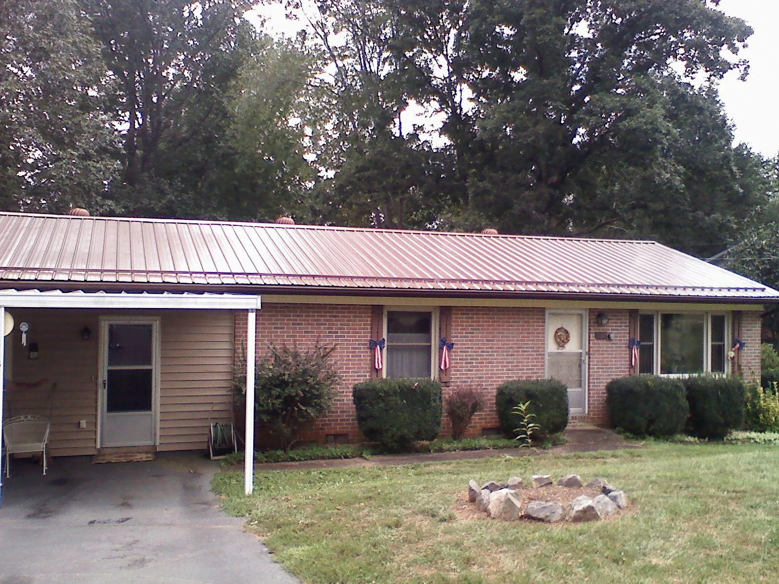 Bronze metal roof and carport on a brick ranch home — Roof Repair work by our crew in Ramey